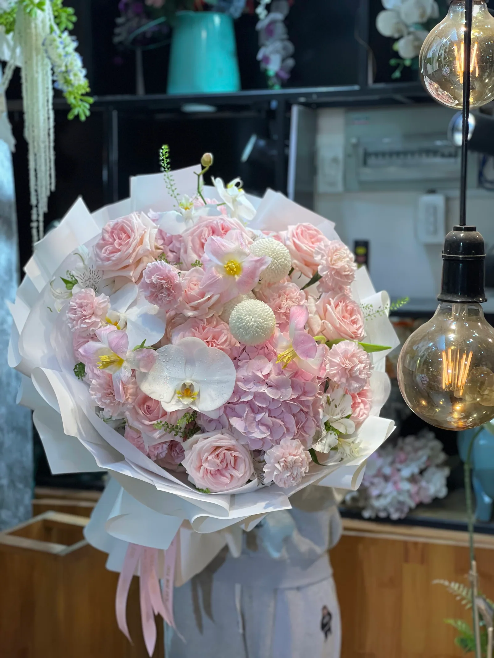 Hoa tươi bày kín kệ gỗ bên trong cửa hàng Sweet Garden Đà Lạt